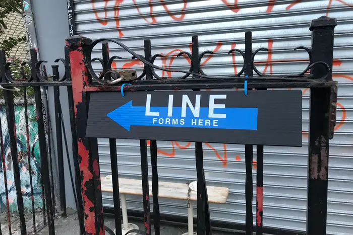 A "line forms here" sign outside of the since-shuttered Archie's Bar & Pizza on August 6th, 2020.